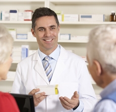 American pharmacist with senior couple in pharmacy