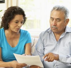 Senior Couple Studying Financial Document At Home